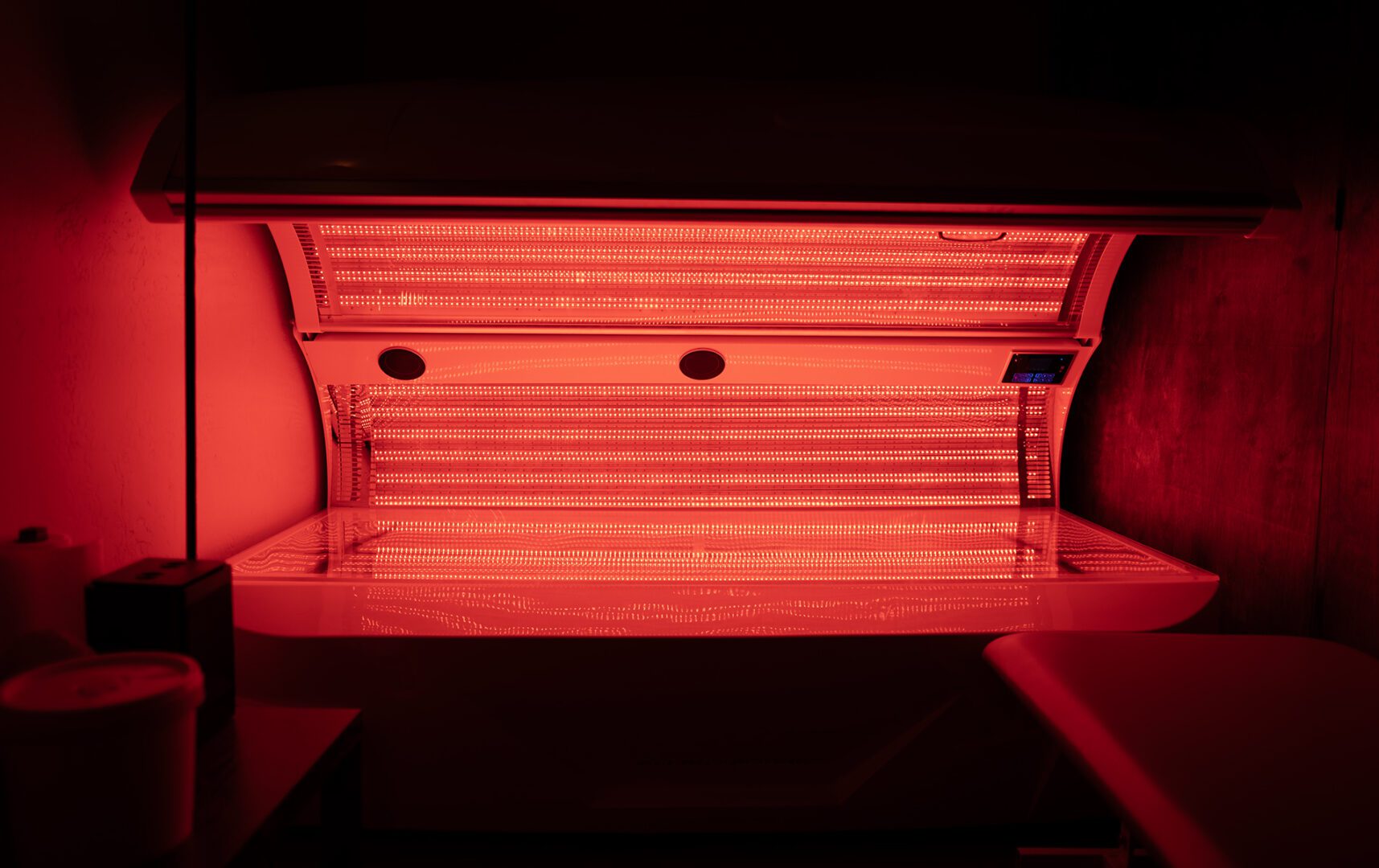 A tanning bed with red lights on it.