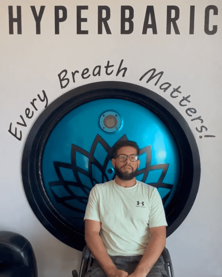 A man standing in front of a wall with a blue ball.